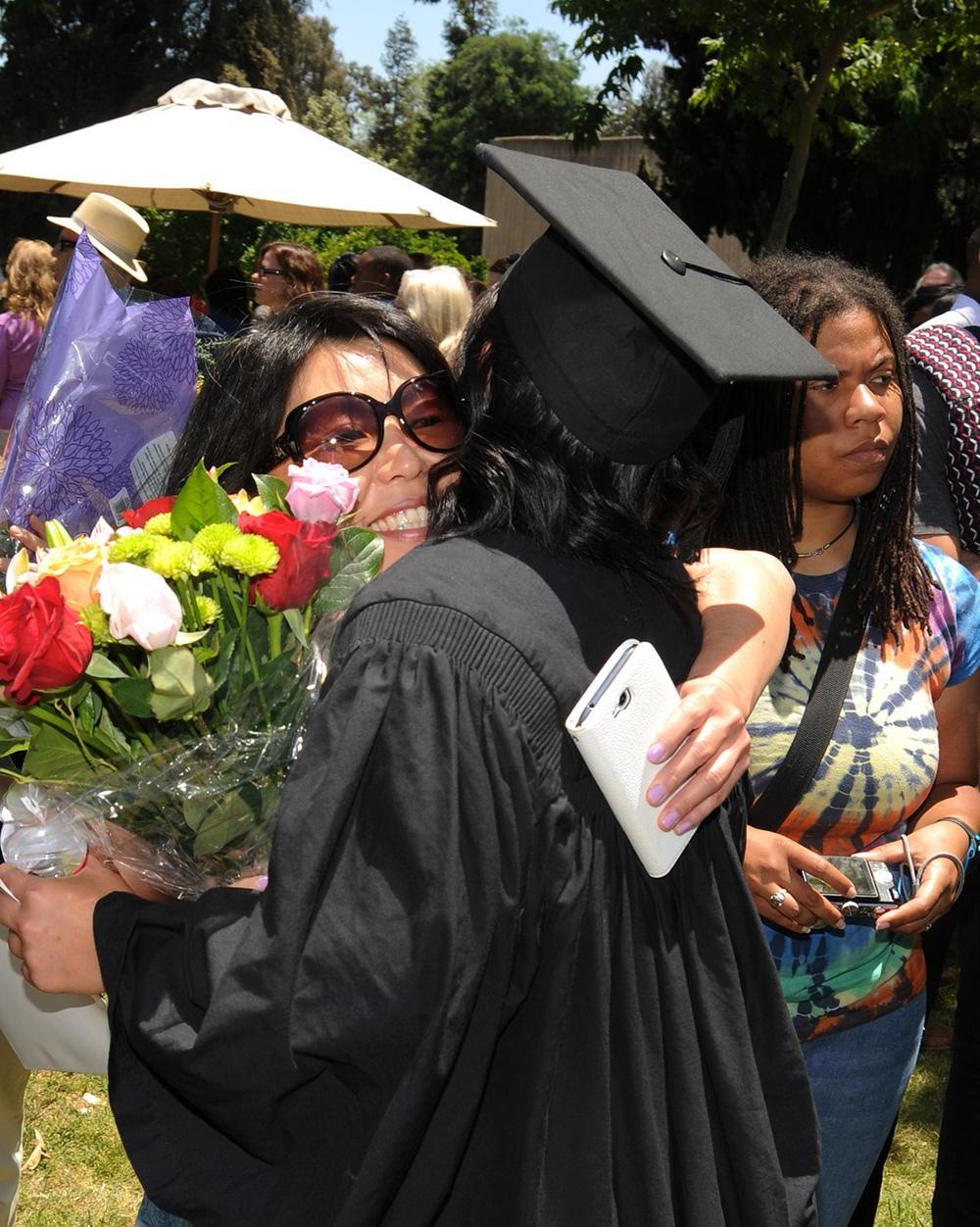 A family hugging at Pomona College Commencement